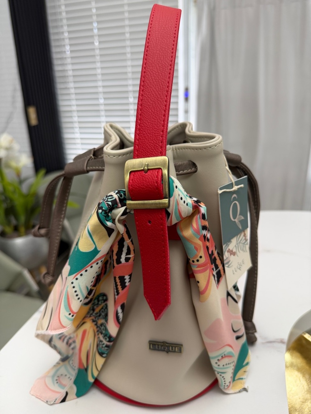 Beige Bucket Shoulder Bag with Red Strap and Multicolor Scarf Accent